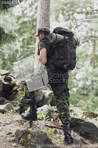 Image of young soldier with backpack in forest