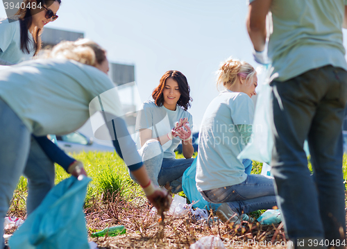 Image of volunteers with garbage bags cleaning park area