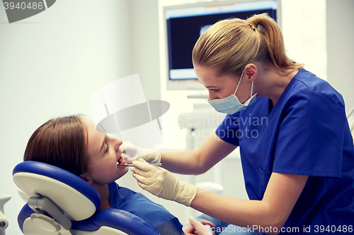 Image of female dentist checking patient girl teeth