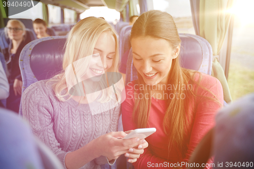 Image of happy young women in travel bus with smartphone