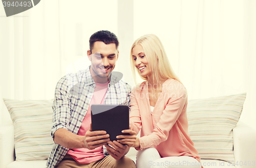 Image of smiling happy couple with tablet pc at home