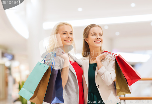 Image of happy young women with shopping bags in mall