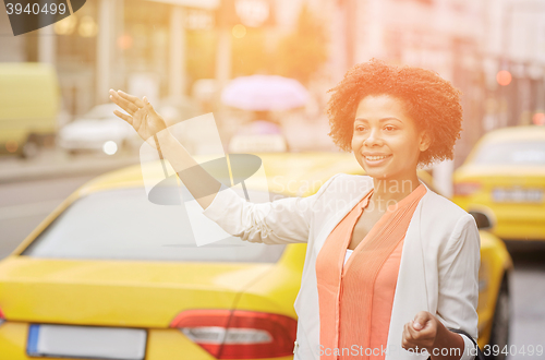 Image of happy african woman catching taxi