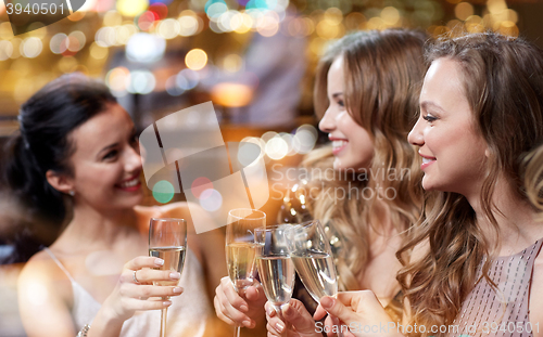 Image of happy women with champagne glasses at night club