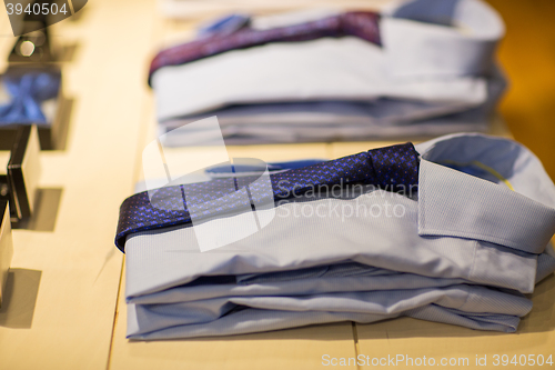 Image of close up of shirts with ties at clothing store