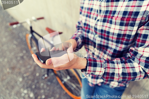 Image of close up of hipster man with smartphone and bike