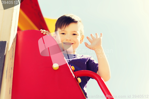 Image of happy little boy climbing on children playground