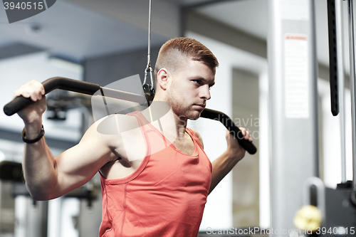 Image of man flexing muscles on cable machine gym