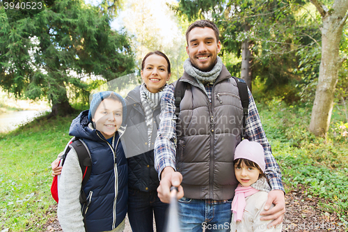 Image of family with backpacks taking selfie and hiking