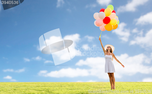 Image of smiling young woman in sunglasses with balloons