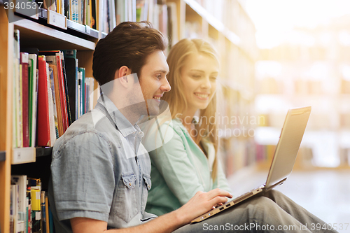 Image of happy students with laptop in library