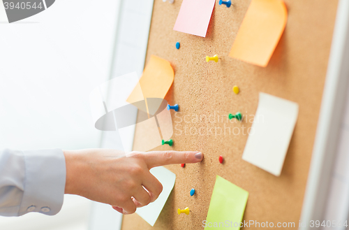 Image of hand pointing to cork board with stickers and pins