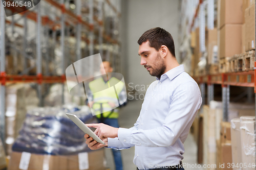 Image of businessman with tablet pc at warehouse