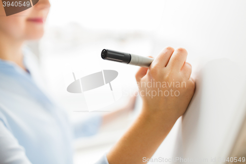 Image of close up of woman writing something on white board