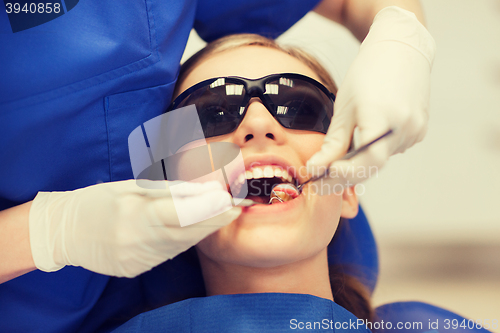 Image of female dentist checking patient girl teeth