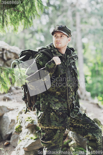 Image of young soldier with backpack in forest