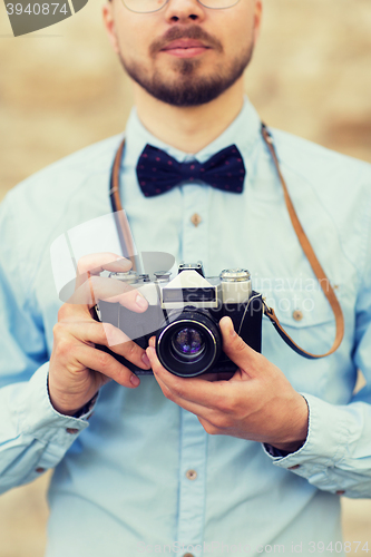 Image of close up of hipster man with film camera in city