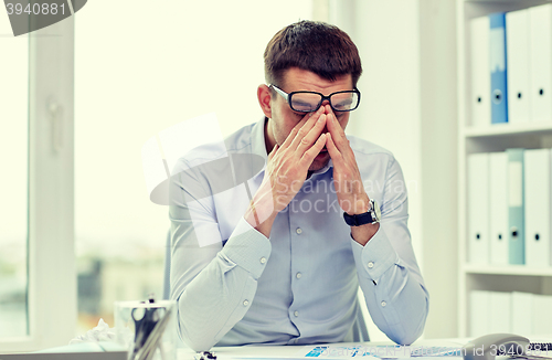 Image of tired businessman with eyeglasses in office