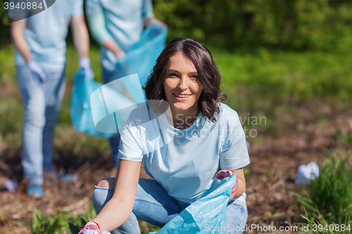 Image of volunteers with garbage bags cleaning park area