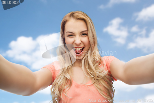 Image of happy smiling young woman taking selfie