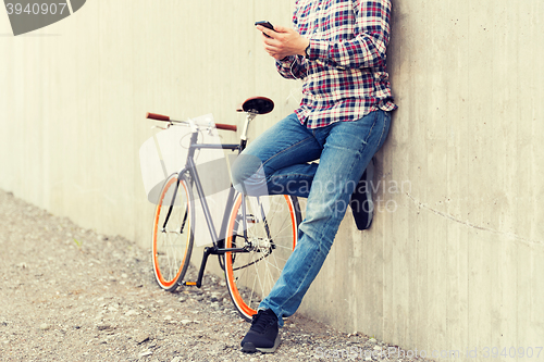 Image of close up of hipster man with smartphone and bike