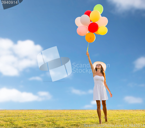 Image of smiling young woman in sunglasses with balloons