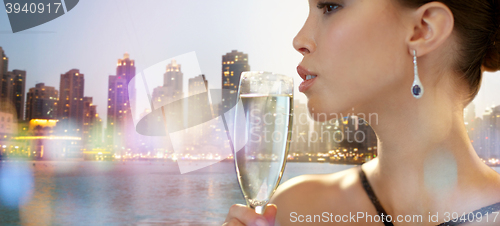 Image of close up of woman drinking champagne in night city