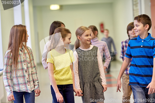 Image of group of smiling school kids walking in corridor