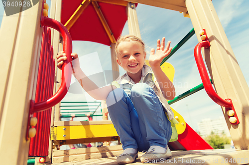 Image of happy little girl climbing on children playground