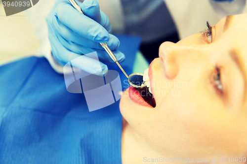 Image of close up of dentist examining female patient teeth