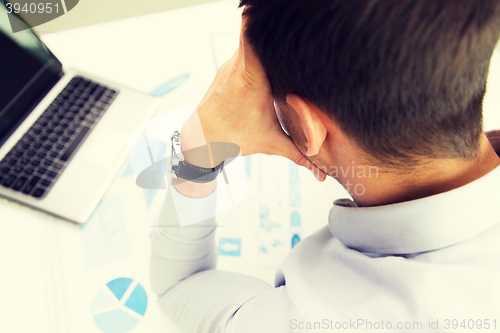 Image of close up of businessman with laptop and papers