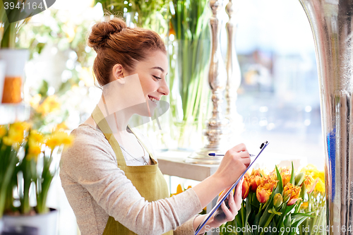 Image of florist woman with clipboard at flower shop