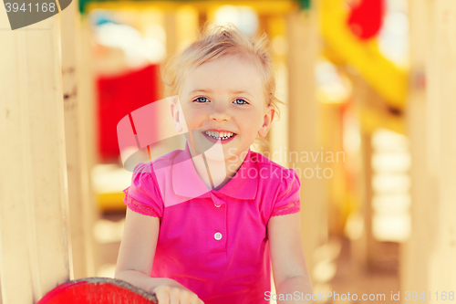 Image of happy little girl climbing on children playground
