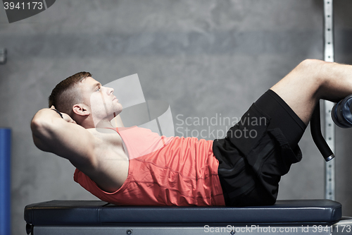 Image of young man making abdominal exercises in gym