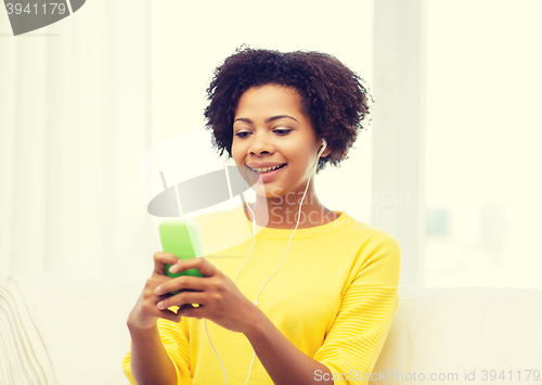 Image of happy african woman with smartphone and earphones