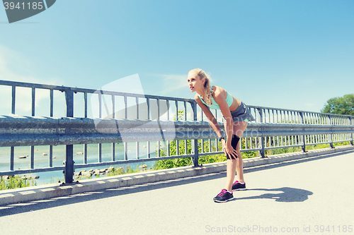 Image of young woman with injured knee or leg outdoors