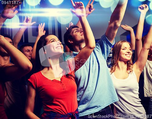 Image of smiling friends at concert in club