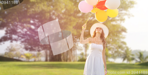 Image of smiling young woman in sunglasses with balloons