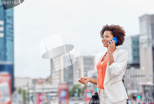 Image of happy african businesswoman calling on smartphone