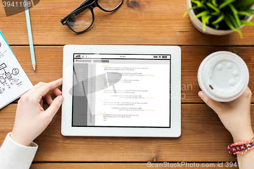 Image of close up of woman with tablet pc on wooden table