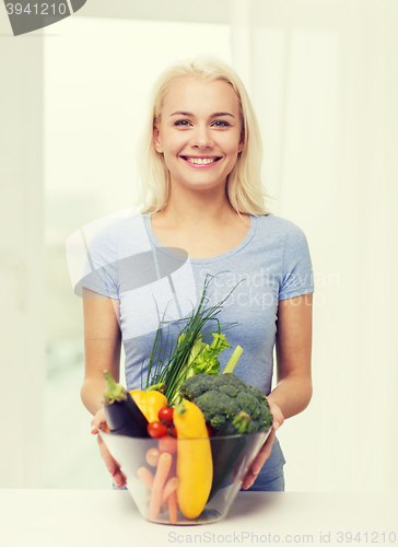 Image of smiling young woman with vegetables at home