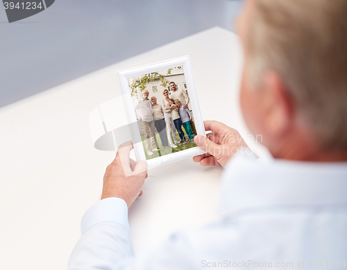 Image of close up of old man holding happy family photo