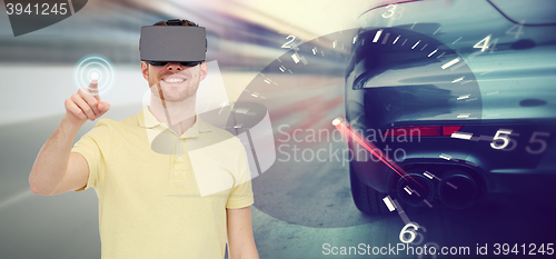 Image of man in virtual reality headset and car racing game