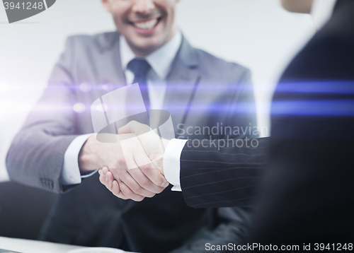 Image of two businessmen shaking hands in office