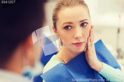 Image of male dentist with woman patient at clinic