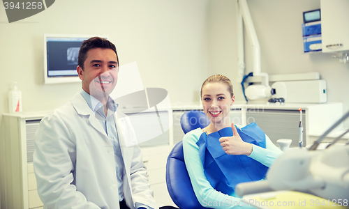 Image of happy male dentist with woman patient at clinic