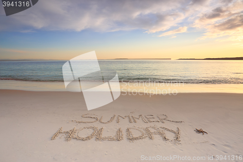 Image of Summer Holiday etched into the sand of beach