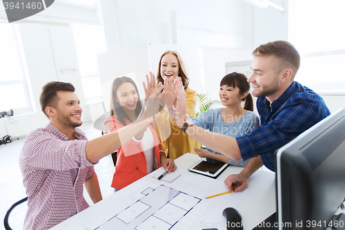 Image of creative team making high five at office