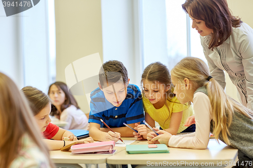 Image of group of school kids writing test in classroom