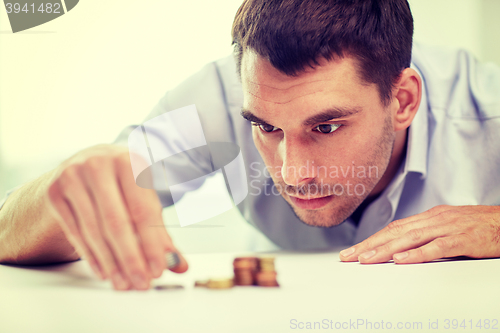 Image of businessman with coins at office